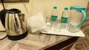 a tray with bottles of water and a blender on a counter at Smooth Checkin By Edition Blue - Mumbai in Mumbai