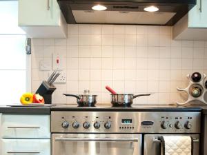 eine Küche mit Herd und zwei Töpfen drauf in der Unterkunft Tintern Abbey Cottage in Tintern