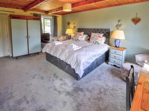 a bedroom with a large bed and a couch at Hadrians Garden Villa in Bardon Mill