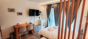 a bedroom with a bed and a desk and a television at Apartman Aska - Residence Hill in Kopaonik