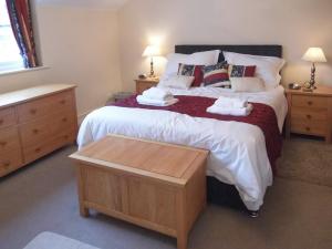 a bedroom with a large bed with towels on it at School Knott Cott in Windermere