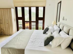 a large white bed in a room with windows at Villa southern coast in Kamburugamuwa