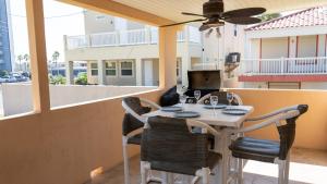 a table with chairs and a laptop on a balcony at Four Bedroom Two Level Home Near Beach in South Padre Island
