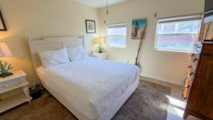 a bedroom with a white bed and a window at Four Bedroom Two Level Home Near Beach in South Padre Island