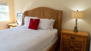 a bedroom with a bed with a red pillow on it at Four Bedroom Two Level Home Near Beach in South Padre Island