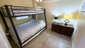 a bedroom with two bunk beds and a night stand at Four Bedroom Two Level Home Near Beach in South Padre Island