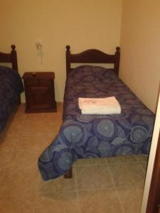 una piccola camera da letto con un letto e un comodino di Mar del Faro a Mar del Plata