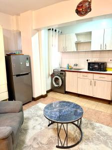 a living room with a table and a kitchen at Emeli Hotel Luxury Suite in Nairobi
