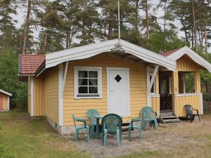 een klein geel huis met een tafel en stoelen bij 5 person holiday home in MELLBYSTRAND-By Traum in Mellbystrand
