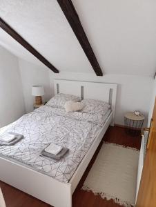 a bedroom with a white bed in a attic at Studio Apartman Ivan in Otočac