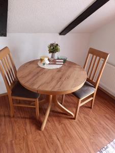 a wooden table with two chairs and a table with flowers at Studio Apartman Ivan in Otočac +3 photos