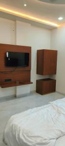 a bedroom with a bed and a flat screen tv at 4Everstay By Prem Ratan Premium Rooms With Free Parking & Wifi !!! Best Family Hotel In Vrindavan in Vrindāvan