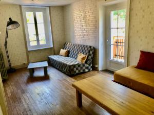 uma sala de estar com um sofá e uma cama em Gîte Au Moulin Mazaud em Ambazac