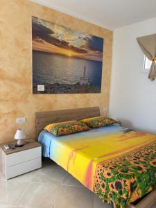 a bedroom with a bed with a painting on the wall at Masseria Causio in Giurdignano