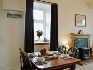 a dining room with a wooden table and chairs at Shore Cottage in Bellochantuy