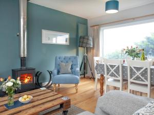 Una sala de estar con chimenea y una pared azul. en Semybadazee, en Poundstock 23 fotos más