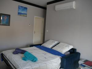 a bedroom with a bed with a blue pillow on it at L'Enclos de La Grande Flûte in Douzat