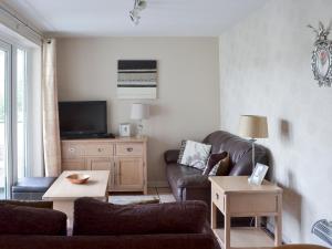 ein Wohnzimmer mit Sofa und Fernseher in der Unterkunft Pine Rigg - Quarry Rigg in Bowness-on-Windermere