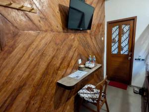 a room with a wooden wall with a tv on it at ZEN MOON Hostel in Yogyakarta