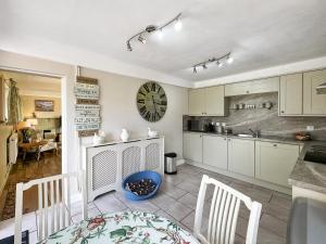 a kitchen with a table and chairs and a clock on the wall at Broadoak Barn in Ellesmere