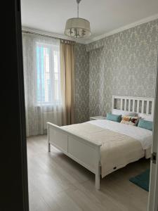 a bedroom with a large white bed in a room at Квартира в центре города in Astana