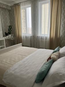 a bedroom with a bed with pillows and a window at Квартира в центре города in Astana +10 photos