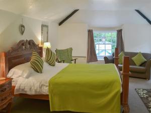 a bedroom with a large bed with a yellow blanket at Caradon Apt - Cv14 in Saint Cleer