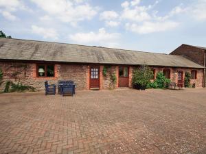 a brick building with a table and chairs in front of it at Bridle Cottage in Hoarwithy