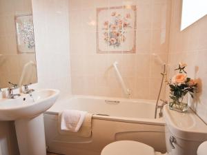 a bathroom with a sink and a tub and a toilet at Bridle Cottage in Hoarwithy