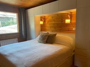 a bedroom with a large bed with a wooden headboard at Chalet Ardoise - Nature Paradise - Swiss Alps in Ovronnaz