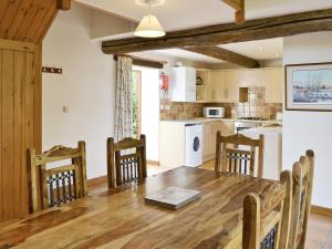 Una cocina y un comedor con mesa y sillas de madera. en Sorrel - E4321, en Ludham