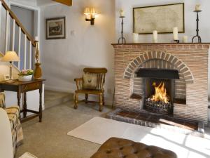 a living room with a brick fireplace and a chair at Toad Hall in Helmsley