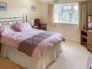 a bedroom with a large bed and a window at Pipit Cottage in Burnsall