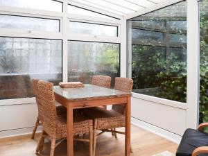 a table and chairs in a room with windows at Valentine Cottage in Keswick