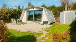 a small house with a window and a table and chairs at Chalet de détente in Métabief