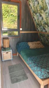 a small room with a bunk bed and a window at Chalet de détente in Métabief