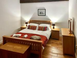 a bedroom with a bed and two night stands and a desk at Murton Cottage in East Ord +7 photos