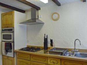 eine Küche mit Spüle, Herd und Uhr in der Unterkunft Hayrake in Ambleside