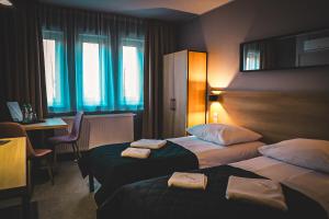 SkorkaにあるHotel Bastioのベッド2台と机があるホテルの部屋