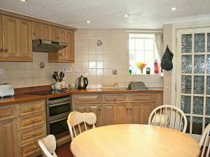 a kitchen with wooden cabinets and a wooden table at Flagstaff Cottage in Robin Hood's Bay