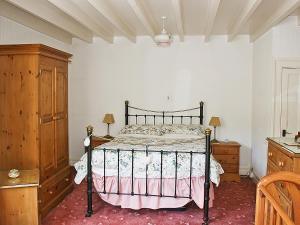 a bedroom with a bed and a wooden cabinet at Flagstaff Cottage in Robin Hood's Bay