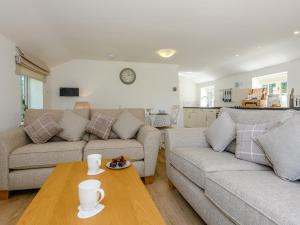 a living room with two couches and a table at The Chicken Coop in Fulletby