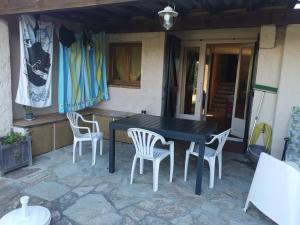 a black table and chairs on a patio at Maison accueillante à Calcatoggio avec jardin clôturé. in Calcatoggio +12 photos