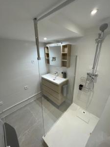 a white bathroom with a sink and a mirror at Atelier Marius ROCHE in Marseille
