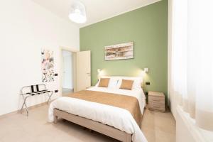 a bedroom with a large bed and a green wall at B&b Casa Spano in Selargius