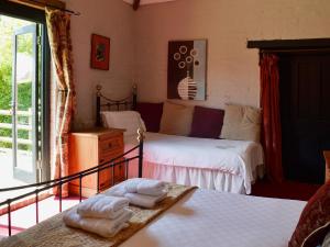 a bedroom with two beds and a balcony at Brook Barn in Ellingham +4 photos