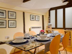 a dining room with a glass table and chairs at The Byre in Ninfield