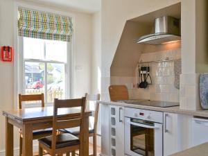 a kitchen with a table and a dining room at 14 Greta Villas in Keswick
