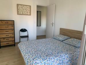 1 dormitorio con cama, silla y vestidor en Agréable 2 pièces à 150 m de la mer, en Cagnes-sur-Mer