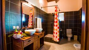 een badkamer met 2 wastafels en een toilet bij Villa Makoa in Nosy Be